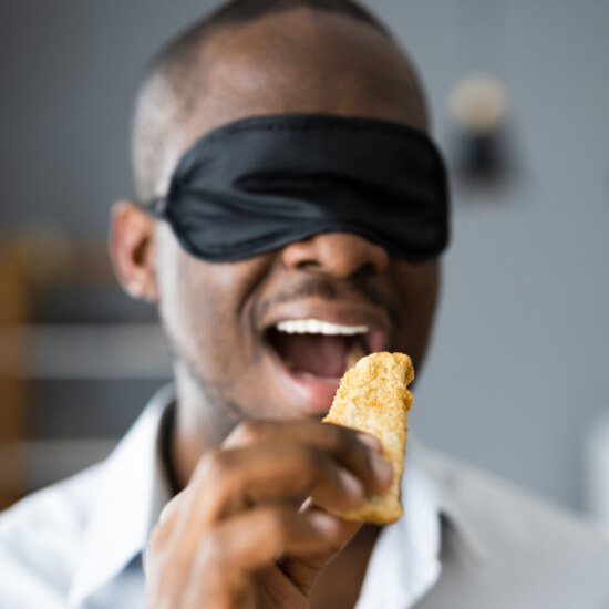 Blindfold Food Taste. African Men Blindfolded Tasting
